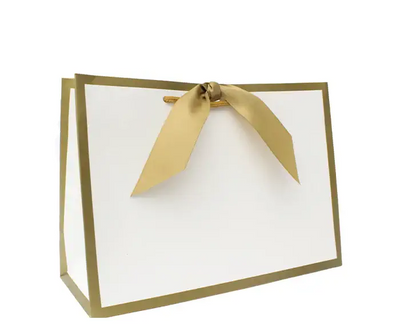 A medium-sized luxury gift bag with a white base and gold edges, featuring a gold grosgrain ribbon.
